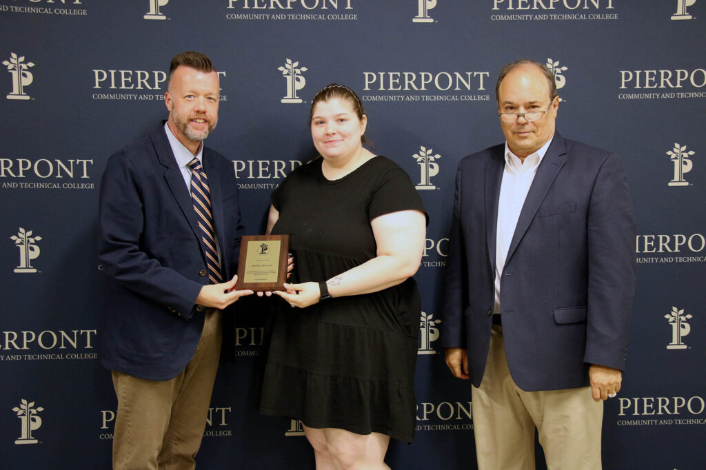 Jessica Killon receives a plaque from Dr. Michael Waide, Interim President, and David Hinkle, Board of Governors Chair