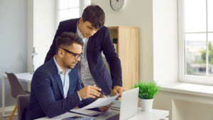 Two men are reviewing a document together.