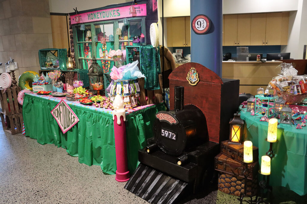 The Physical Therapist Assistant program’s Harry Potter-themed display, featuring Honeydukes candy and a Platform 9¾ backdrop, is shown during the Community Trick-or-Treat event. The program won Best Table in the event’s internal contest.