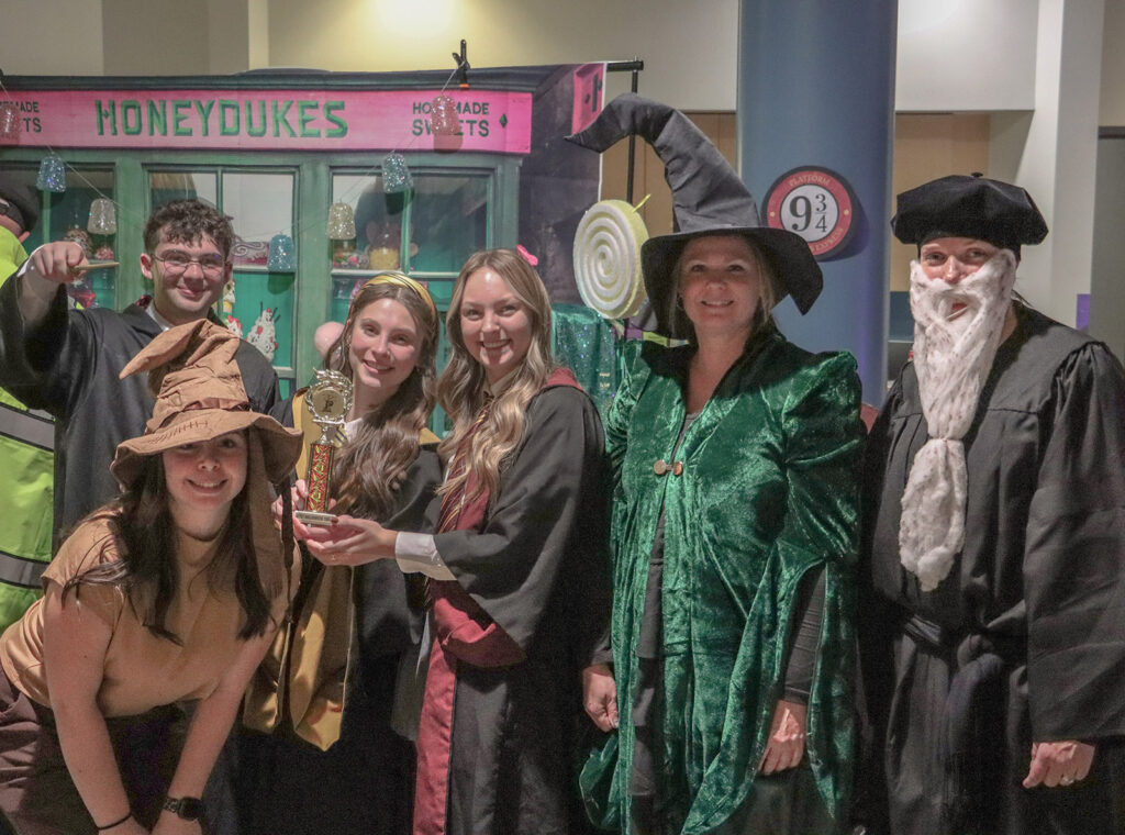 Faculty and students in Pierpont Community and Technical College’s Physical Therapist Assistant program pose with their award for Best Table during the Community Trick-or-Treat event. Their Harry Potter-themed display featured Honeydukes candy and Platform 9¾ décor.