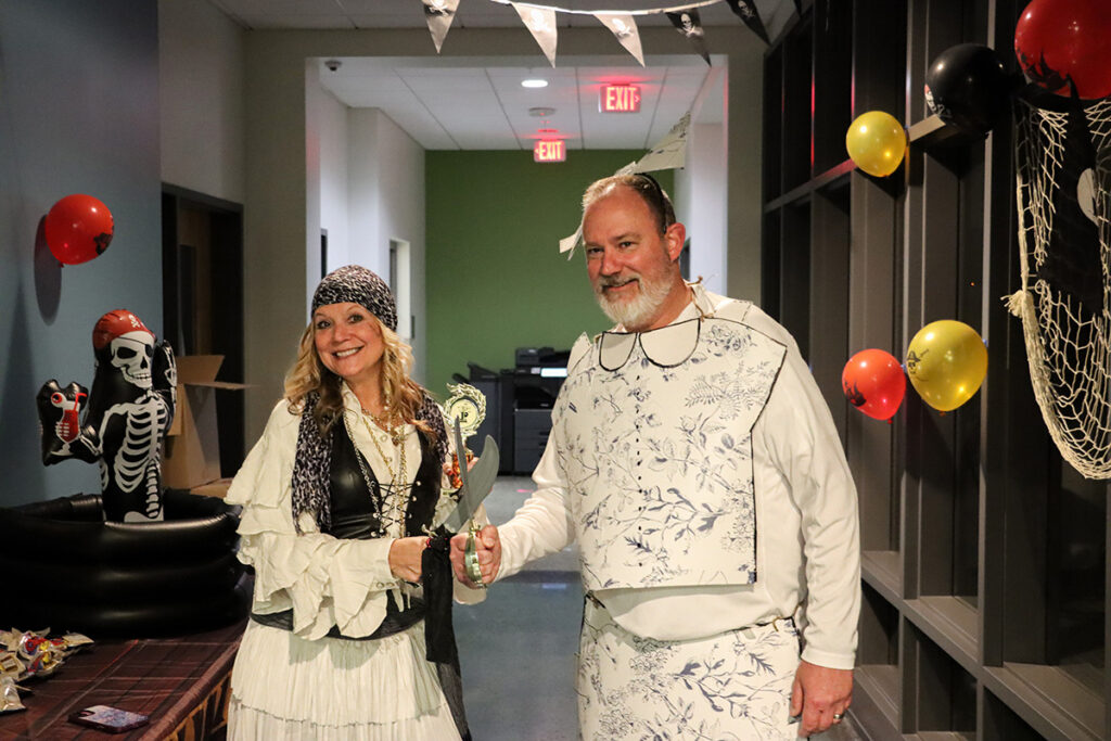 Melissa Weikle receives the Best Costume award from David Beighley, Interim Provost and Vice President of Academic Affairs at Pierpont, during the Community Trick-or-Treat event. Weikle wore a pirate costume as part of the pirate-themed table.
