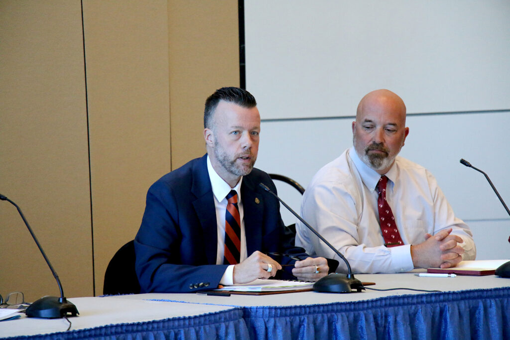 Dr. Michael Waide speaks into a microphone during the Higher Education Presidents Panel as Dr. Michael Davis listens beside him.