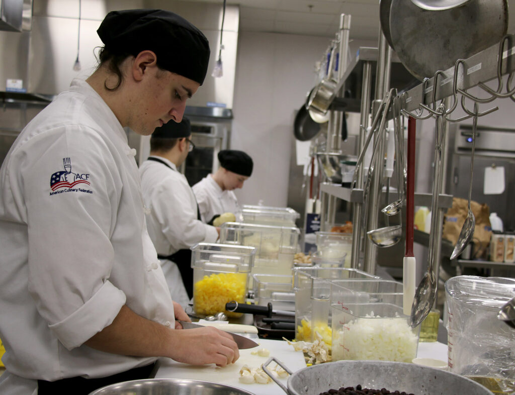 Matthias Freeman, a Food Service Management, Culinary Arts student at Pierpont Community & Technical College, chops ingredients in the college’s Culinary Academy kitchen while preparing turkeys for the Union Rescue Mission’s Thanksgiving outreach in Fairmont, W.Va.