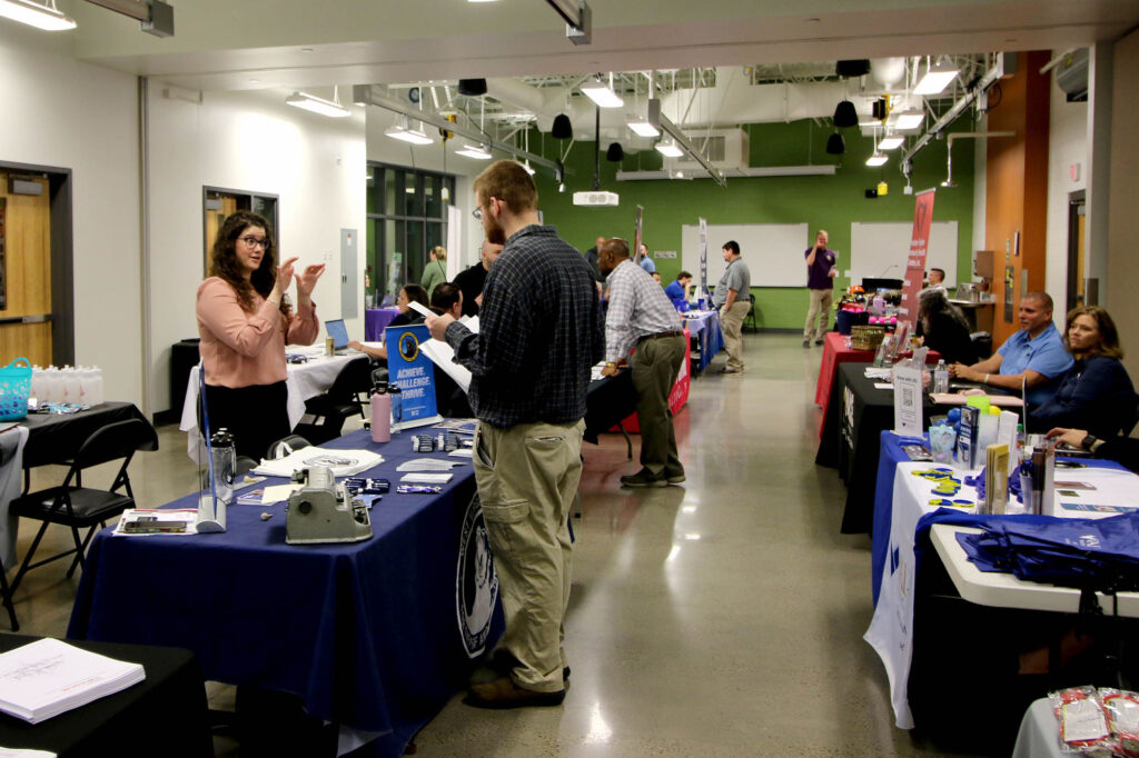 Attendees speak with employer representatives during a career fair at Pierpont Community & Technical College’s Advanced Technology Center, where vendors from multiple fields shared information about available career pathways.