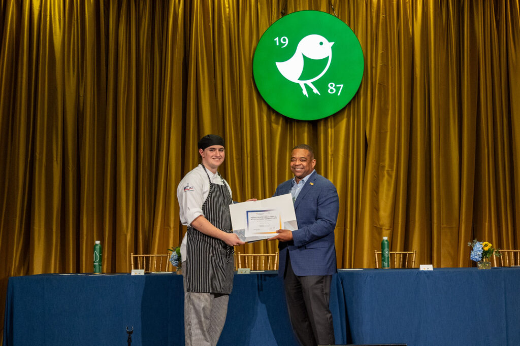 Matthias Freeman, left, a Food Service Management student at Pierpont Community & Technical College, accepts an award during the 3rd Annual WVU Culinary Competition at Nemacolin, where he finished second overall and won People’s Choice honors.