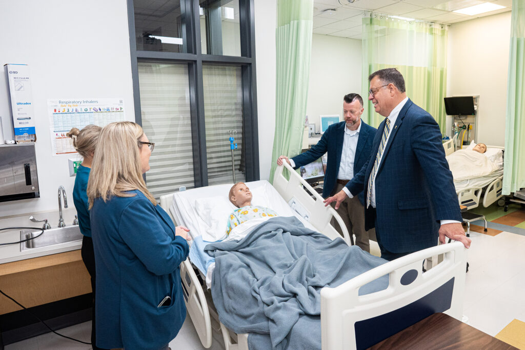 West Virginia Sen. Michael A. Oliverio II participates in an LPN simulation alongside Pierpont Community & Technical College President Dr. Michael Waide on Monday.