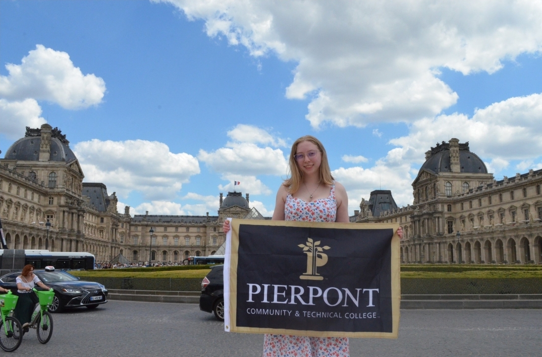 Martin is featured holding a Pierpont flag in front of The Louvre.