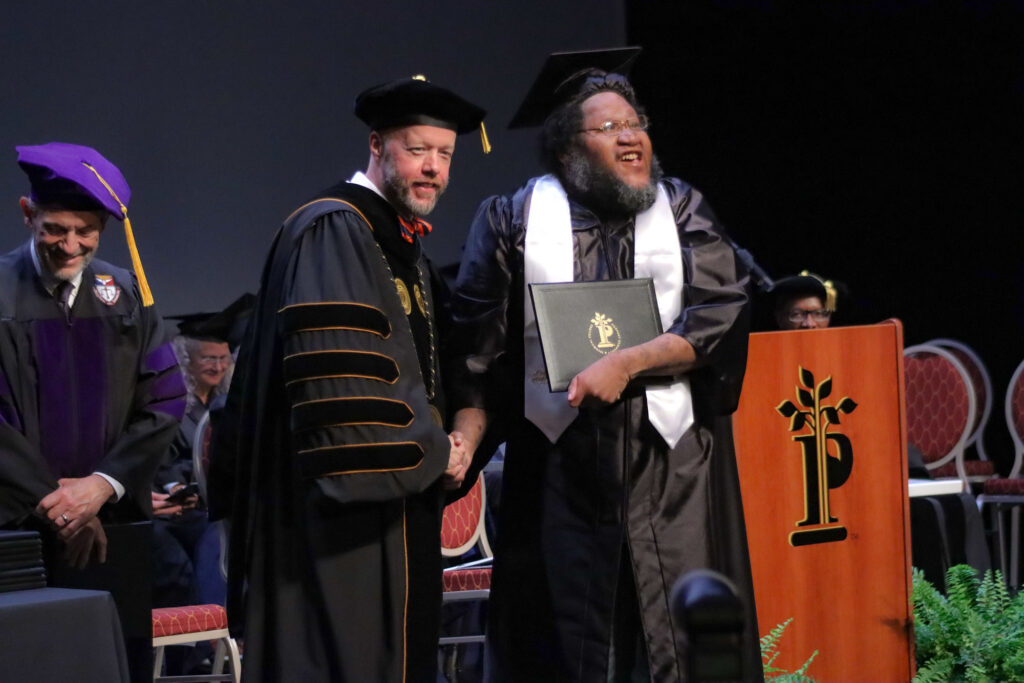 Dr. Waide shakes hands with graduate Deshon Porter during the 2025 Graduation Ceremony.