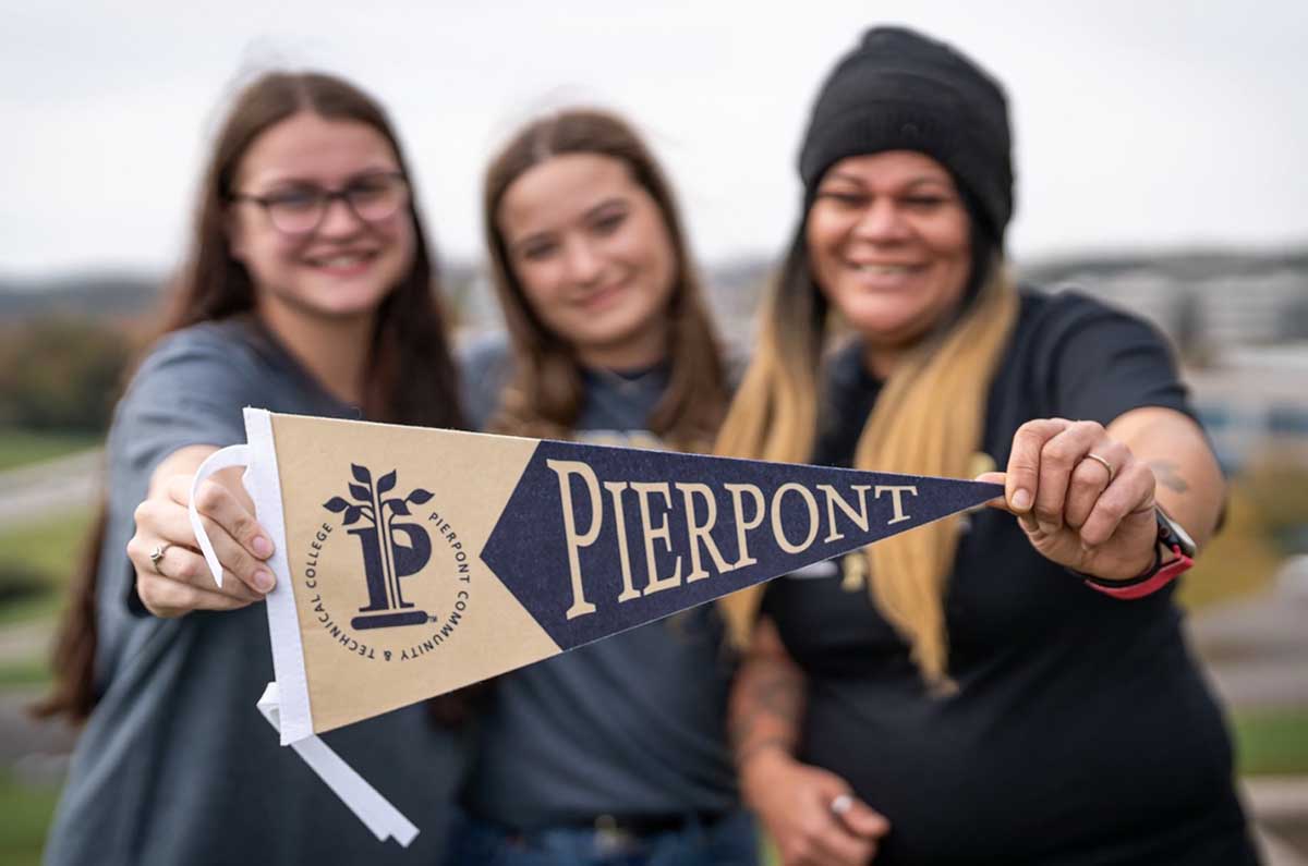 Students hold a Pierpont pennant at the Advanced Technology Center.