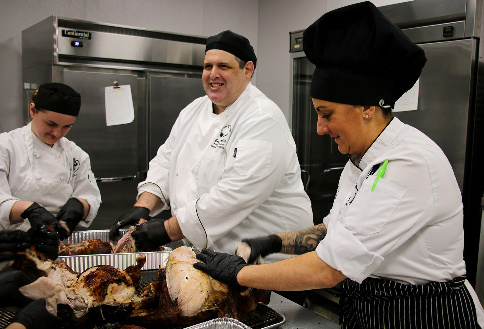 From left, Leah Summers, a Food Service Management, Culinary Arts student, works alongside Executive Chef and Instructor Tony Anobile and Instructor Sara Feltz as they prepare roasted turkeys at Pierpont Community & Technical College’s Culinary Academy for the Union Rescue Mission’s Thanksgiving outreach in Fairmont, W.Va.