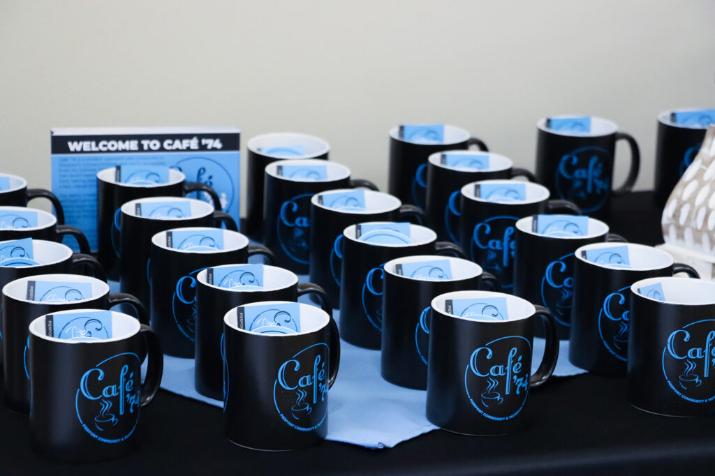 Café ’74 branded mugs are displayed during the ribbon cutting celebration, offering attendees a keepsake from Pierpont Community & Technical College’s student‑run café.
