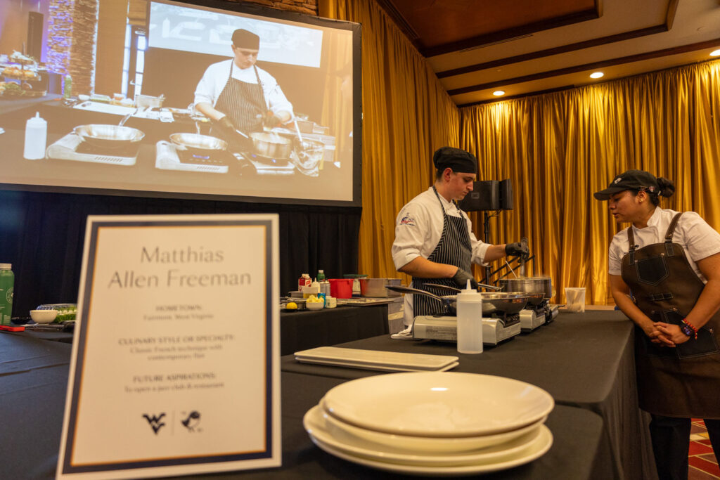 WVU Photo. Pierpont culinary student Matthias Freeman, center, prepares his entrée during the 3rd Annual WVU Culinary Competition at Nemacolin.