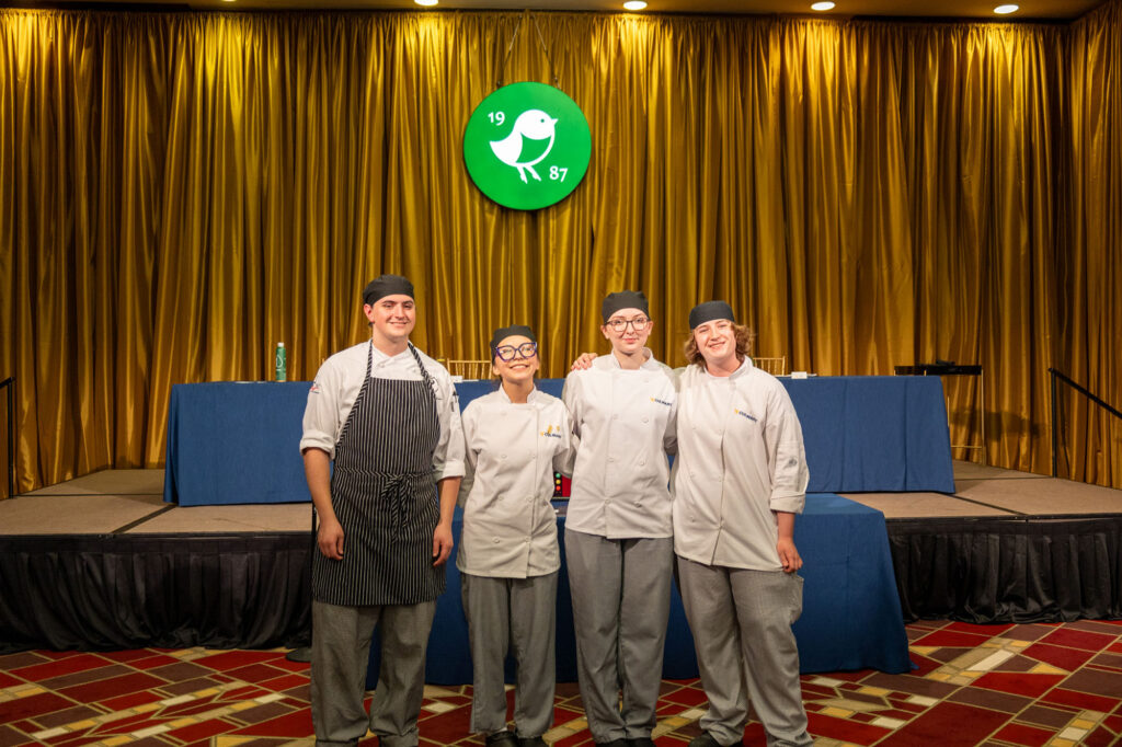 Students from participating colleges gather on stage during the 3rd Annual WVU Culinary Competition at Nemacolin. The event brought together culinary students from across West Virginia to compete in a timed, fine-dining challenge.