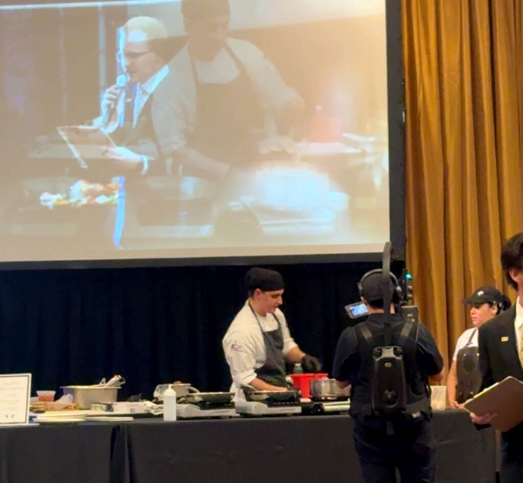 Culinary competitors prepare dishes under timed conditions as judges and attendees observe during the 3rd Annual WVU Culinary Competition at Nemacolin.