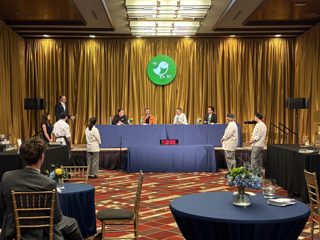 Judges confer as student competitors stand ready during the 3rd Annual WVU Culinary Competition at Nemacolin. The event marked Pierpont Community & Technical College’s first year participating.