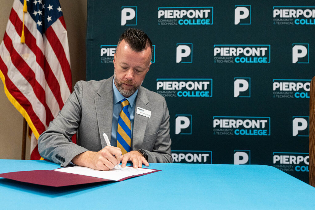 Dr. Michael Waide signs the agreement with Fairmont State University to expand access to bachelor's and master's degree programs for eligible Pierpont employees at a reduced tuition rate.