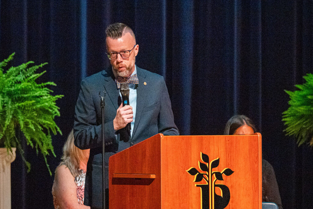 Dr. Michael Waide speaks from the podium during Pierpont Community & Technical College's Licensed Practical Nursing Pinning Ceremony. Waide addressed graduates, families and guests, reflecting on the perseverance and persistence that led the Class of 2026 into the nursing profession.