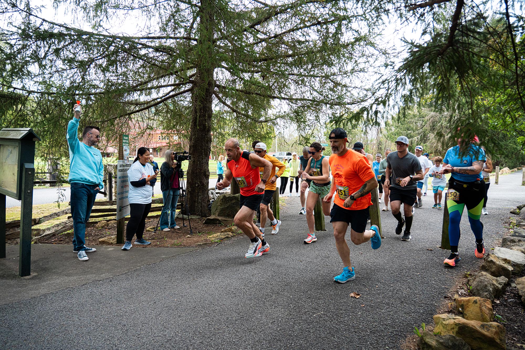 Runners leave the starting line after Dr. Michael Waide, President of Pierpont Community & Technical College, sounds the air horn and Miki DeMary-Andrew gives the starting commands for the inaugural Fall in Love with Health 5K at Prickett’s Fort State Park in Fairmont, W.Va.